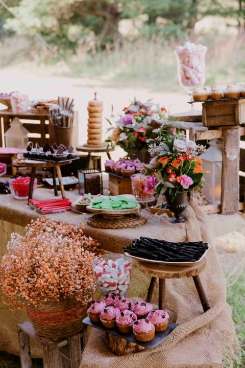 Mesa dulce con pasteles y gominolas en la celebración de un evento.